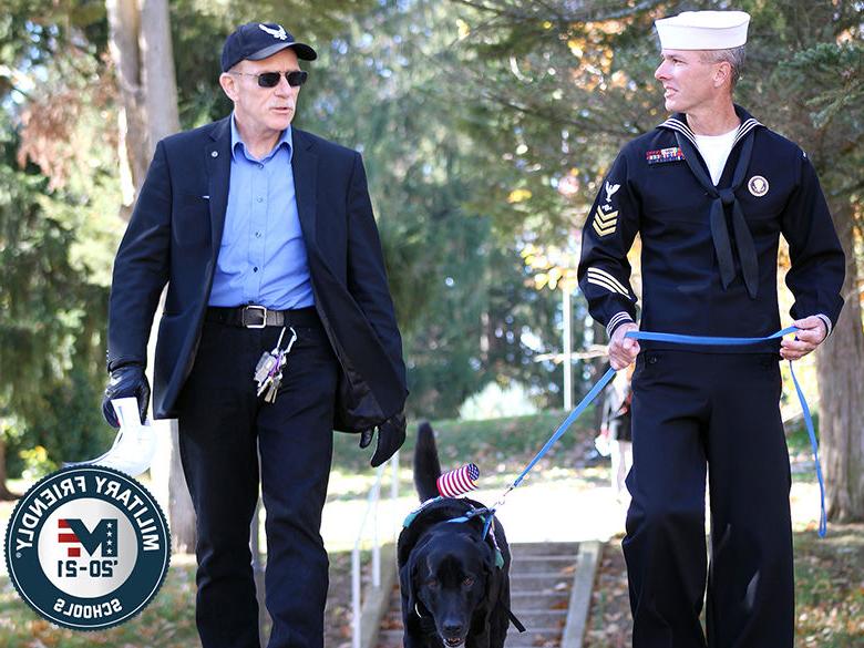 退伍军人学生与服务犬和退伍军人教官一起散步